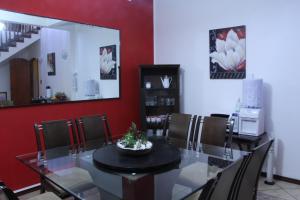 a dining room with a glass table and chairs at Pousada Sognares in Guarulhos