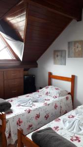 a bedroom with two beds and a window at Pousada Sognares in Guarulhos