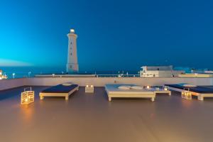 um quarto com três camas e um farol em Casa del Faro em Torre Canne