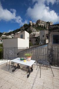 a table and a chair on a balcony at Terrazzo Vinicio in Scicli