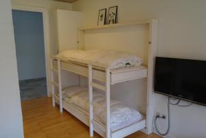 a room with two bunk beds and a flat screen tv at Agervig Bed & Breakfast in Næsbjerg