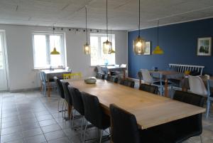 a dining room with a large wooden table and chairs at Agervig Bed & Breakfast in Næsbjerg