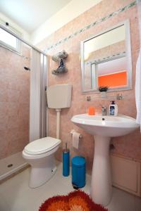 ein Badezimmer mit einem WC, einem Waschbecken und einem Spiegel in der Unterkunft Il Pescatore in Marinella di Selinunte