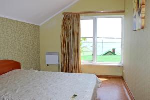 a bedroom with a bed and a large window at Sovinyon in Odesa