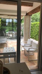 um quarto com um pátio com cadeiras e mesas brancas em Saint-Tropez walking distance, sea view house em Saint-Tropez