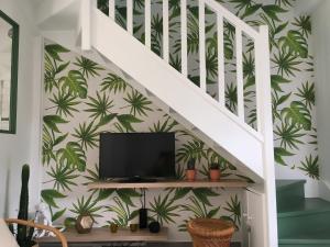 ein Wohnzimmer mit einer Treppe mit Palmblättertapete in der Unterkunft Saint-Tropez walking distance, sea view house in Saint-Tropez
