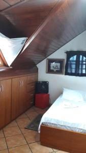 a bedroom with a bed and a wooden ceiling at Pousada Sognares in Guarulhos