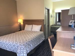 a small hotel room with a bed and a sink at Silver Spruce Inn in Glenwood Springs