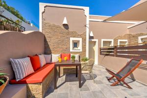 a patio with a bench and a table at MiCasa in Oia