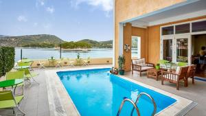 a swimming pool with a view of the water at Lazaretto Palace in Vathi