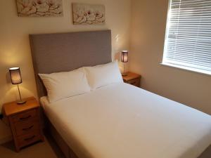 a bedroom with a large white bed with two lamps at Dublin Airport Room in Dublin
