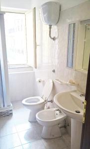a white bathroom with a toilet and a sink at Climatizzato in Centro a 100m dal mare in Cirò Marina