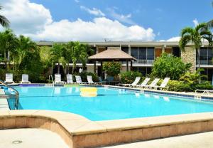 a large swimming pool with chairs and a building at Dolphin Key Resort - Cape Coral in Cape Coral