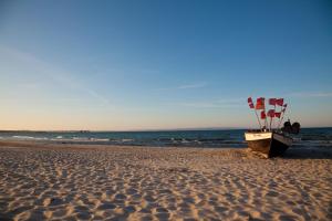 a boat on the beach with flags on it at Ferienwohnungen Familie Glasner in Binz