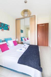 a bedroom with a large bed with pink and blue pillows at Sweet home with spectacular sea view in Paleo Tsifliki
