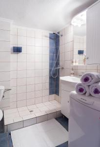 a bathroom with a shower and a toilet with towels at Sweet home with spectacular sea view in Paleo Tsifliki
