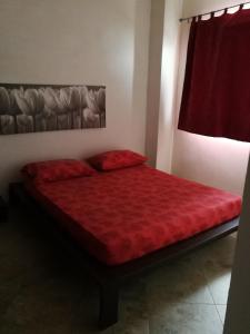 ウッジャーノ・ラ・キエーザにあるL'Asfodelo 2の赤いベッドカバーが備わるドミトリールームのベッド1台分です。