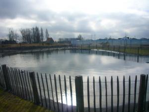 ミッデルケルケにあるZee en polder nummer 16の周囲に柵を持つ水の池