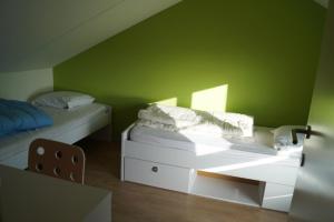 a green room with two beds and a table at Zee en polder nummer 16 in Middelkerke