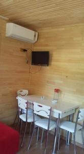 a room with a table and chairs and a fan at Naz Apartlari Cirali in Cıralı