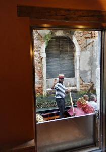 un homme debout dans une fenêtre d'un bâtiment dans l'établissement Casa delle gondole, à Venise