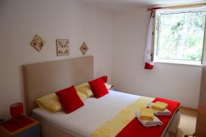 1 dormitorio con 1 cama con almohadas rojas y amarillas en Villa Kale Apartments, en Slatine 50 fotos más