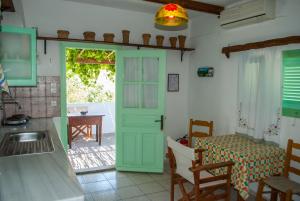 kuchnia z zielonymi drzwiami i stołem w obiekcie PATMOS Mathios Studios- apartments w mieście Patmos