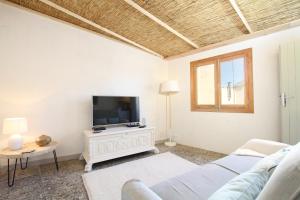 a living room with a couch and a tv at Pollenca Townhouse in Pollença