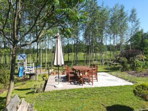 a patio with a table and an umbrella at Wiejska Chata in Szwalk