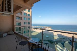 een balkon met stoelen en uitzicht op de oceaan bij Apartamente Gala Residence Eforie Nord in Eforie Nord