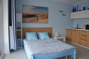 ポゴジェリツァにあるApartament Pogorzelicaのベッドルーム1室(ベッド1台付)が備わります。壁には絵画が飾られています。