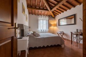 een slaapkamer met een groot bed en een tafel bij Borgo Terrosi in Sinalunga