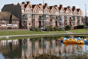 a group of inflatable boats in a river in front of buildings at Arun Sands Rooms in Littlehampton