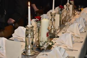 einen langen Tisch mit Kerzen, Servietten und Gläsern in der Unterkunft Hotel Winter in Schöppingen