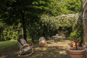 un giardino con sedie e tavolo con fiori di Dimora Rosa Bianca a Macerata