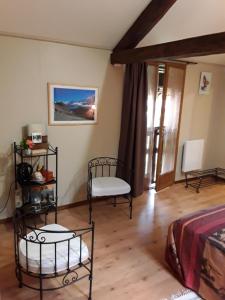 a room with two chairs and a bed in it at La Parenthèse in Saint-Genix-sur-Guiers