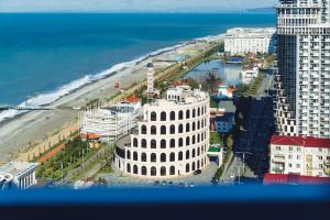 an aerial view of a white building next to the beach at Sky Inn Batumi in Batumi