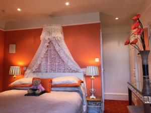 un osito de peluche sentado en una cama en un dormitorio en Arun Sands Rooms, en Littlehampton
