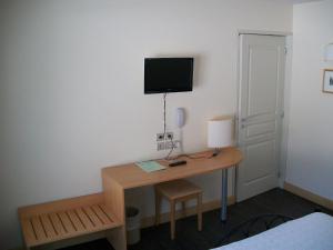 a room with a desk with a television on the wall at Lac des Graves in Lascelle
