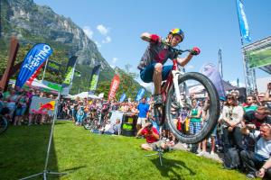 a woman doing a trick on a bike in front of a crowd at Casa Gabbiano in Nago-Torbole