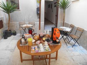 una mesa con comida en una habitación con sillas en La Corte Dei Naviganti, en Trapani