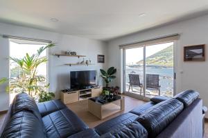 ein Wohnzimmer mit einem Sofa und einem großen Fenster in der Unterkunft Monte da Guia in Horta