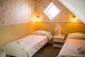 2 camas en una habitación pequeña con ventana en Vanalinna Boutique Hotel, en Kuressaare