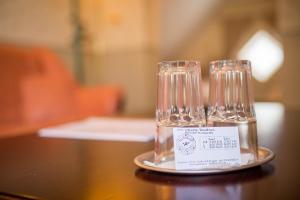 dos copas de vino sentadas en un plato en una mesa en Vanalinna Boutique Hotel, en Kuressaare