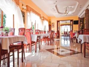 a dining room with tables and chairs in a restaurant at Pensjonat Solis Sarbinowo in Sarbinowo