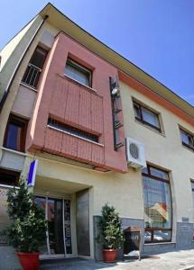 un bâtiment avec un balcon rouge au-dessus dans l'établissement Hotel Maxim, à Svätý Jur