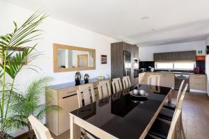 a kitchen and dining room with a black table and chairs at Monte da Guia in Horta