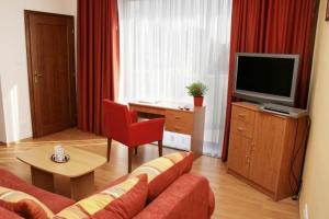 a living room with a couch and a television at Hotel Maxim in Tvrdošín