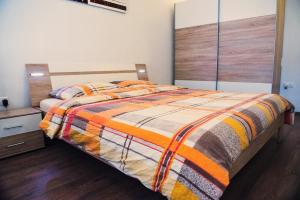 a bedroom with a bed with a colorful blanket at Apartment Tara in Ljubljana