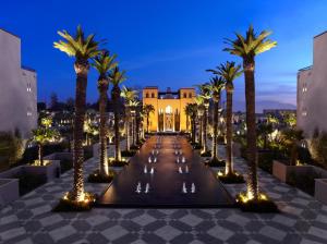a row of palm trees in front of a large building at Four Seasons Resort Marrakech in Marrakech